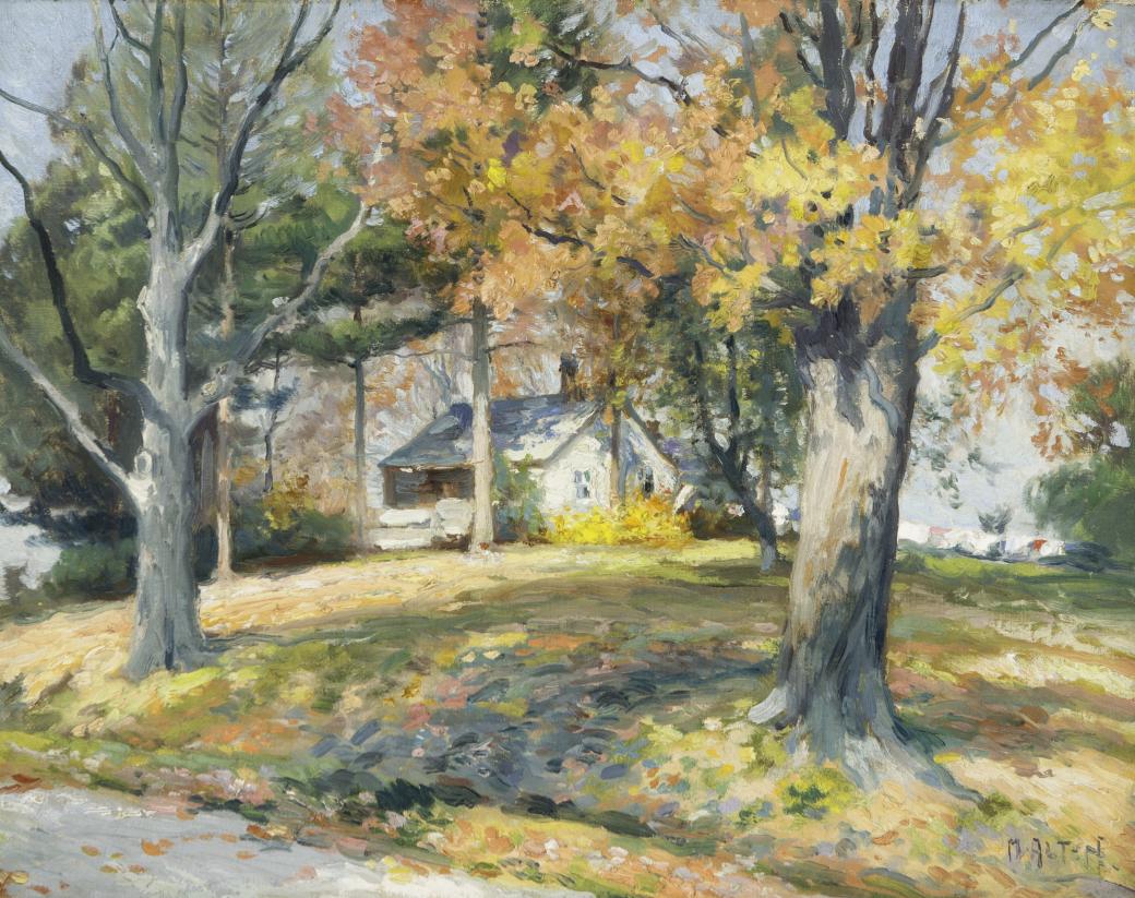 White house tucked into trees with yellow, orange and green leaves.