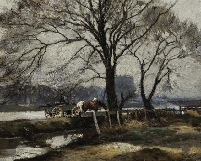 View of horses pulling a green cart along a river.