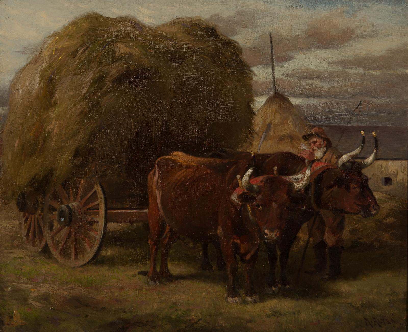 Man with a cart of hay being pulled by two large oxen.