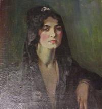 Woman with dark hair and dark veil with a white clip sitting on wooden chair.