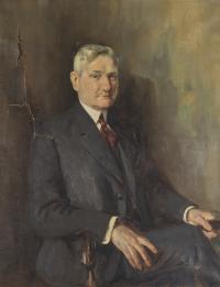 Portrait of a man sitting in a chair.
