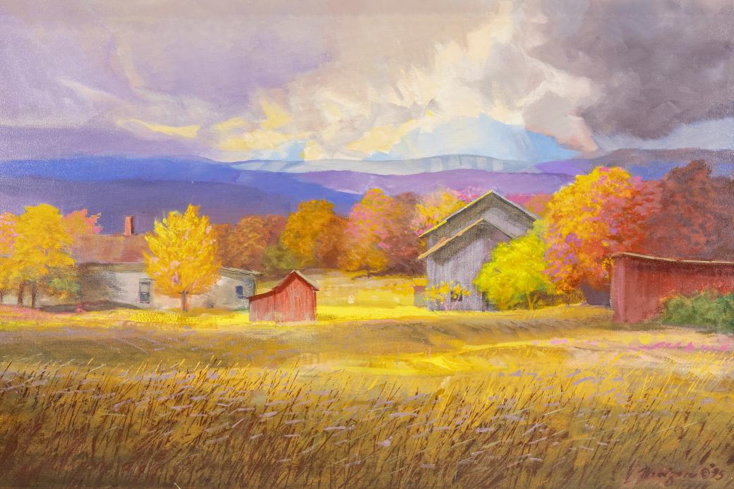 Pastoral landscape with a number of buildings including grey and red barns surrounded by fall colored trees.