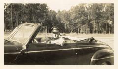 Untitled (Young Man Driving a Convertible Along the Tree-line)