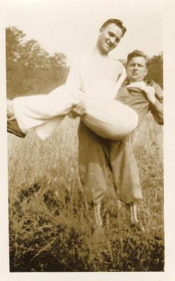 Untitled (A Man Carrying Another Man in a Field Bridal-Style, The Carrier Has Funky Socks)