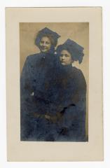 Untitled (Two women wearing dark robes and hats)